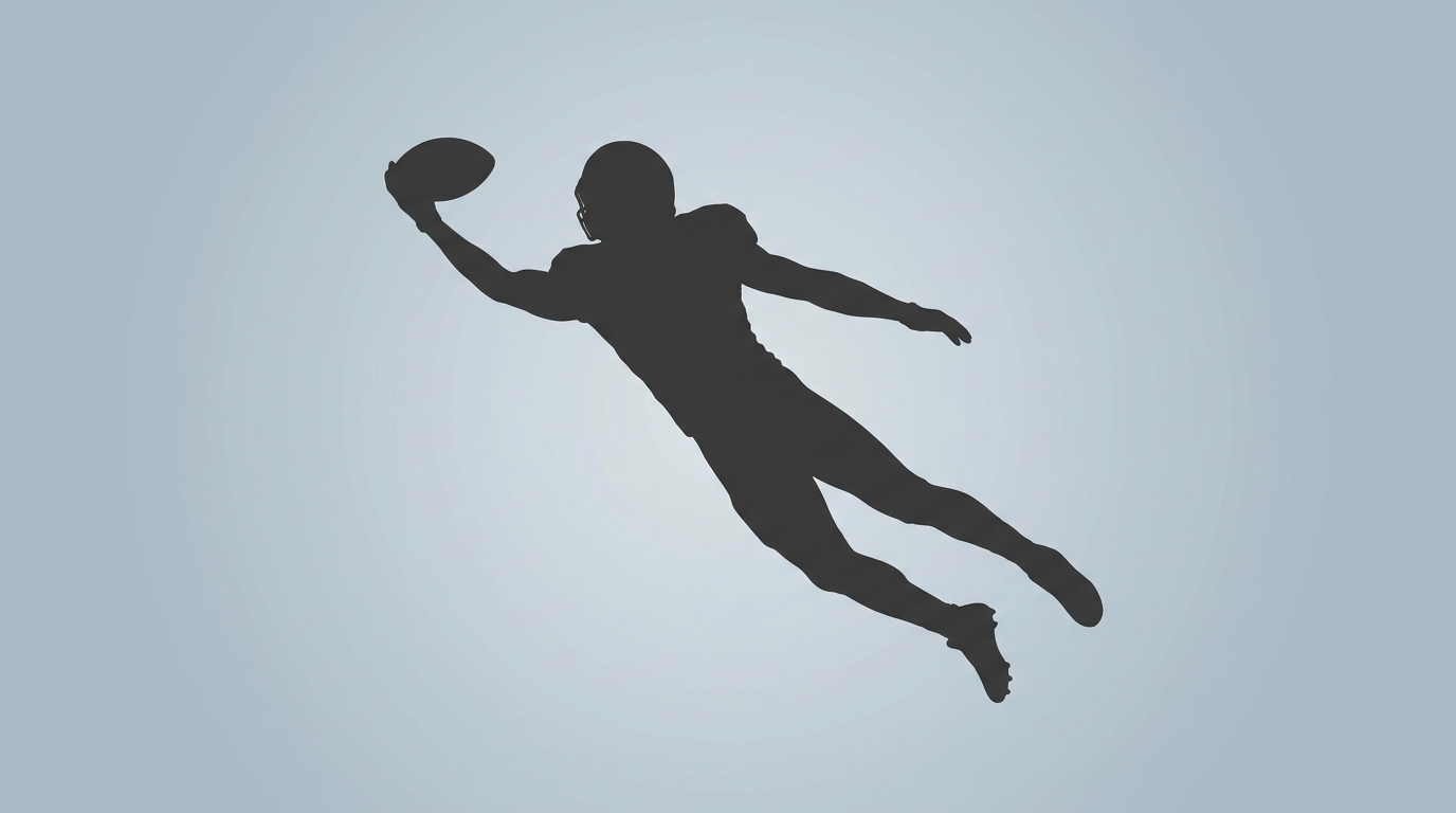 Wide receiver silhouette leaping to catch a football